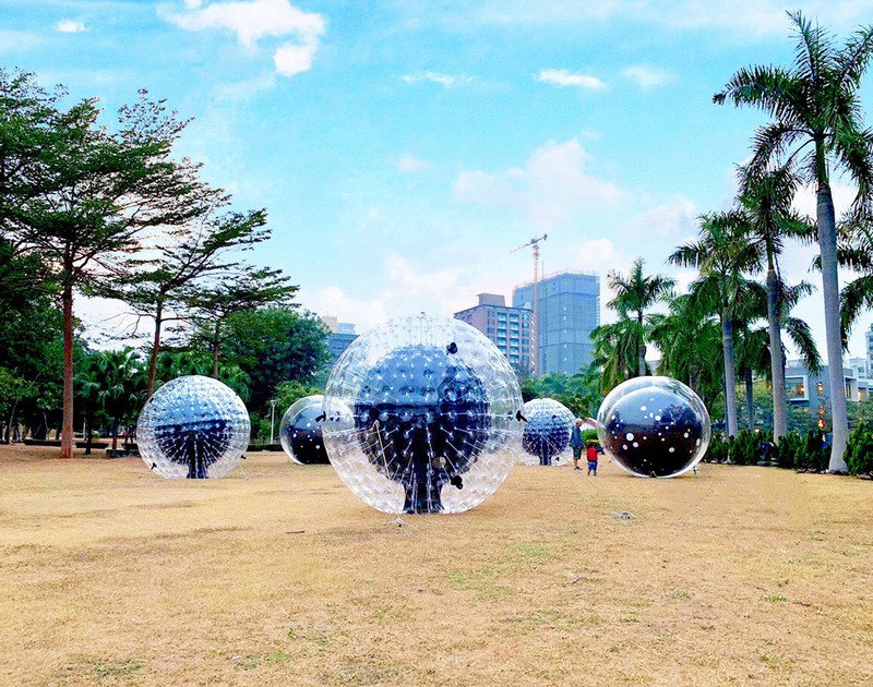 藝術家江忠倫創作的「原子撞球檯」，把數顆設有震動發電裝置的LED燈泡放在充氣球中，可讓民眾進入球裡邊滾邊發光。（台電提供）