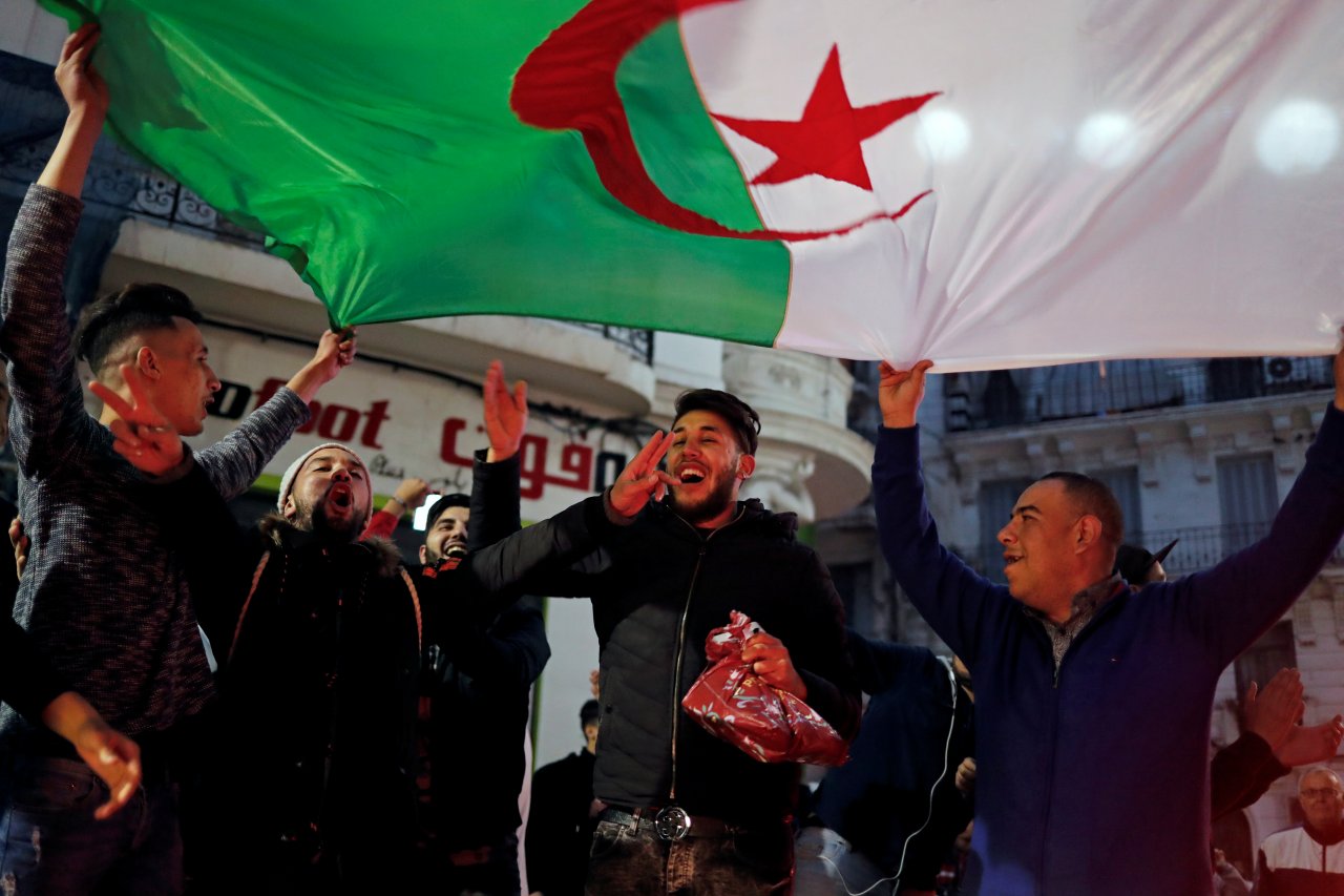 阿爾及利亞總統包特夫里卡宣布放棄第五次競選後，當地人手舉國旗、興奮地湧上街頭狂歡。(路透社/達志影像)