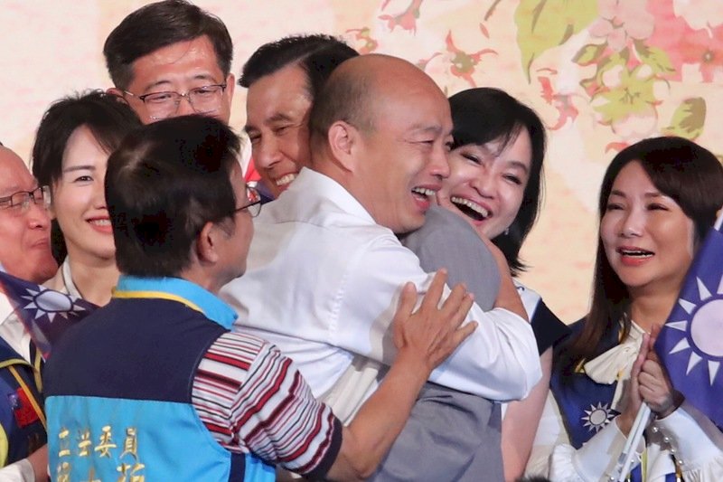 國民黨提名總統參選人韓國瑜(白衣者)15日在台北出席「大陸台商秋節聯誼茶會」,與前總統馬英九(灰衣者)互相擁抱致意。(圖:中央社)