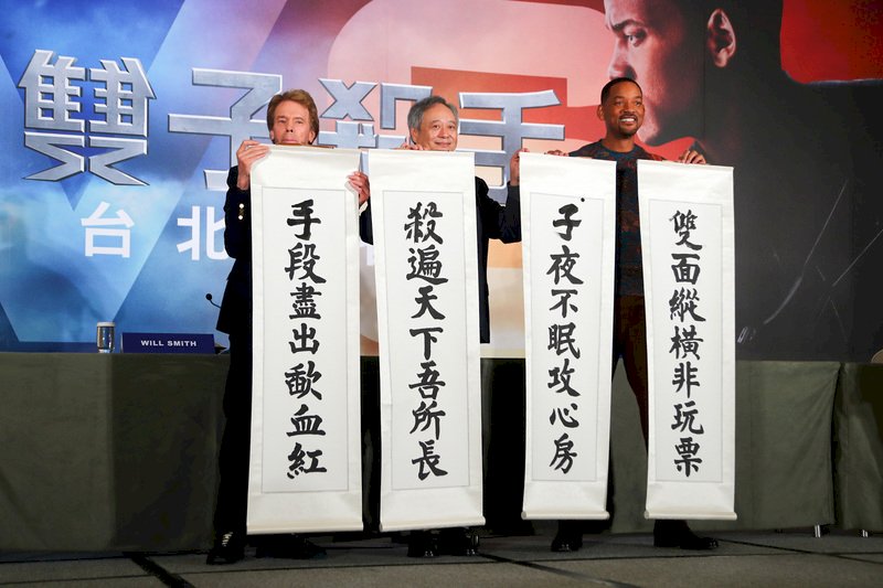 導演李安(中)與美國男星威爾史密斯(Will Smith)(右)、製片傑瑞布魯克海默(Jerry Bruckheimer)(左)21日在台北同為新片「雙子殺手」宣傳造勢,3人揮毫寫下藏頭對聯,預祝電影票房長紅。