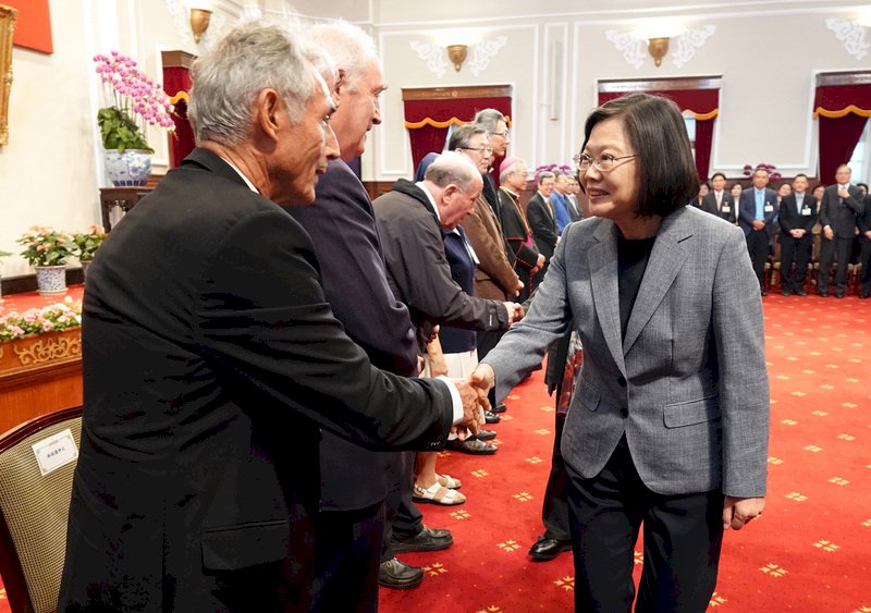 總統蔡英文（右）31日在總統府，接見財團法人天主教會台灣地區主教團外籍傳教士及教友代表，並逐一握手致意。