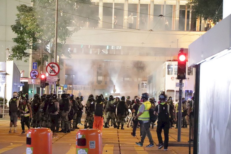 香港「反送中」網友趁著31日萬聖節之際發起集會遊行，許多人不顧禁蒙面法，戴著面具上街。圖為警方晚間10時左右在蘭桂芳附近發射催淚彈驅散示威者。