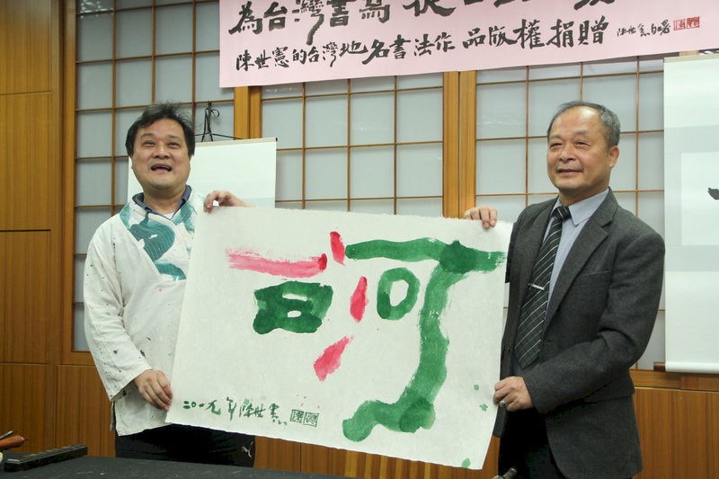 知名意象書法家陳世憲(左)3日在台南市白河區公所宣布捐出以「地誌書法」創作的台灣地名作品版權,並現場揮毫「白河」二字,由白河區長蕭福清(右)代表區公所受贈。