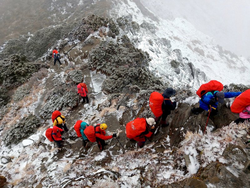南湖大山6日上午降下入冬第一場雪,讓山友相當驚喜,但因持續飄雪,基於安全考量,山友選擇暫時下撤到山屋。(林心聖提供)