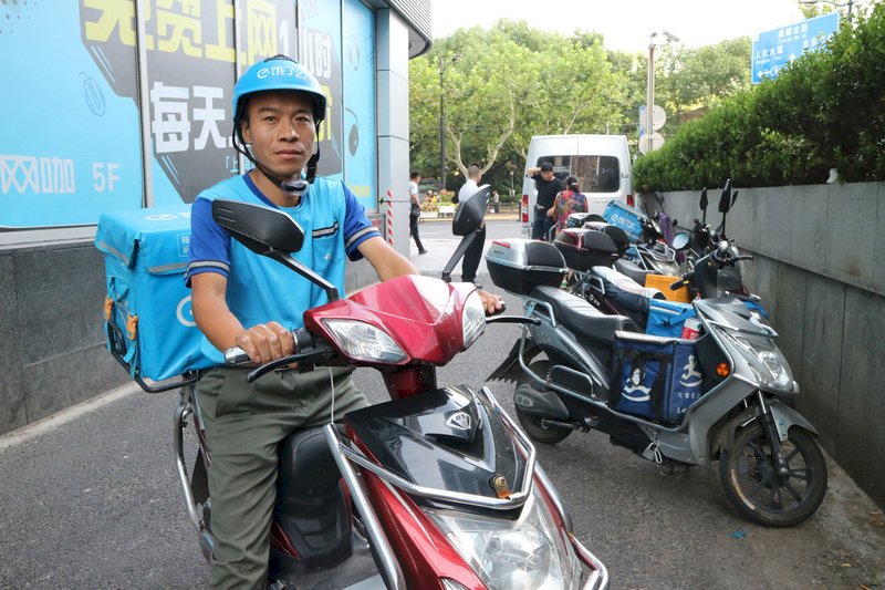中國外賣騎手人數逾百萬，在風吹日曬下使命必達成了鮮明的職業形象。圖為餓了麼外送員張大民，他認為相較一般服務業，當外送員比較自由，這份工作對他來說「挺不錯的」。