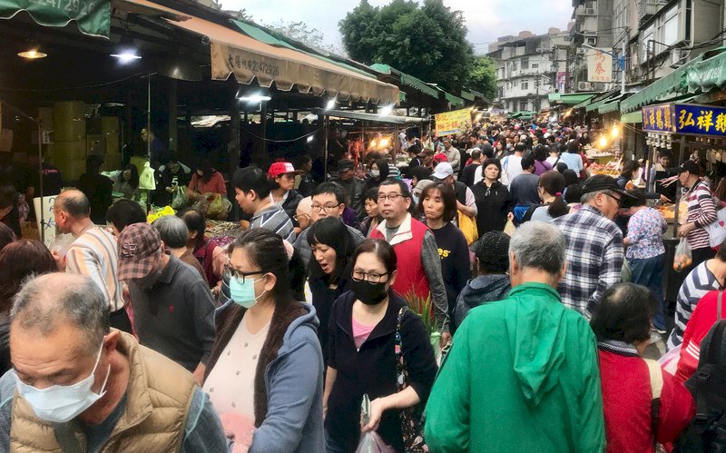 武漢肺炎疫情升溫，23日小年夜傳統市場裡仍湧入採購人潮，部分民眾戴著口罩買年菜。