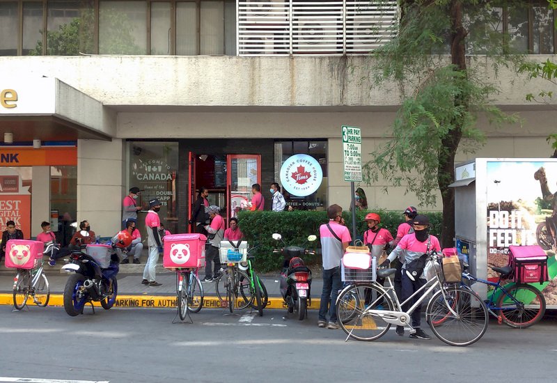 大馬尼拉地區封城超過一週,民眾不出門,外送業生意走俏,馬卡蒂市(Makati)一家提供外送的咖啡店前聚集不少外送員。
