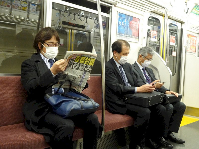 2019冠狀病毒疾病(COVID-19,武漢肺炎)疫情擴散,東京民眾憂封城,搭乘地鐵民眾閱讀頭版為「封城進入秒讀」的報紙。