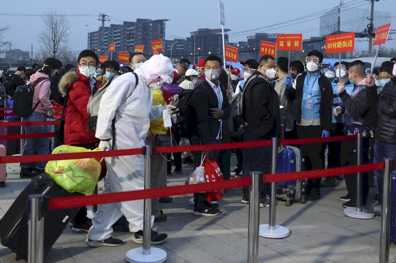 湖北省解封後,滯留當地的北京市民在官方以專列「點對點」運送下,有序分批回到北京並進行14天居家隔離。圖為2020年3月25日海淀區級集中分流點,在核對人員身分後由各街道統一送回住所。(中新社提供)