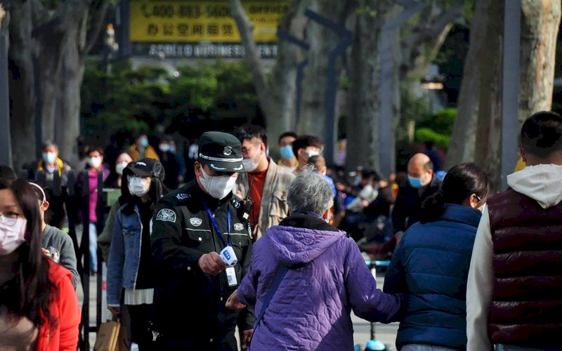 武漢8日解除封城，即便中國看似已恢復日常生活，但不少民眾仍擔心疫情，甚至懷疑官方數據。圖為清明連假上海靜安公園的人潮，保安仍為入園民眾量體溫。