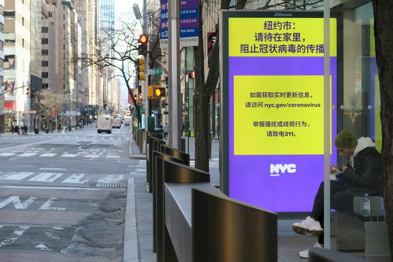 紐約市防止武漢肺炎疫情惡化，公車站廣告看板以簡體中文告示敦促市民盡量待在家，昔日車水馬龍的曼哈頓第五大道車流量銳減。