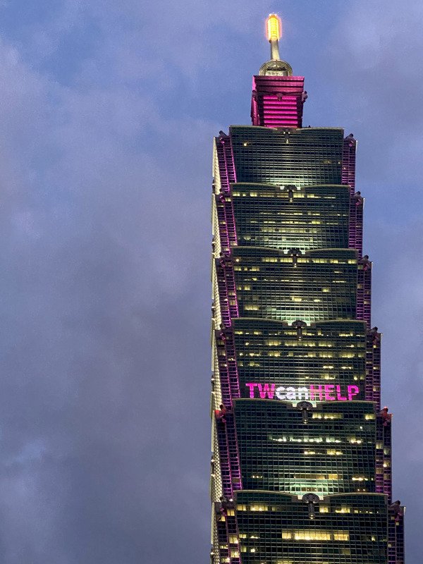 武漢肺炎疫情當前，台北101大樓在15日、16日兩天晚上，在大樓外牆點亮粉紅色燈光，打上TWcanHELP等字樣，透過點燈活動為台灣加油打氣。（台北101提供）