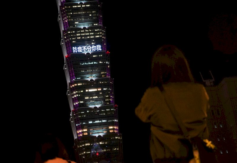 台北101大樓16日晚間在外牆點燈打上「防疫不分你我」等字樣，希望為民眾凝聚信心，也吸引許多民眾駐足欣賞。