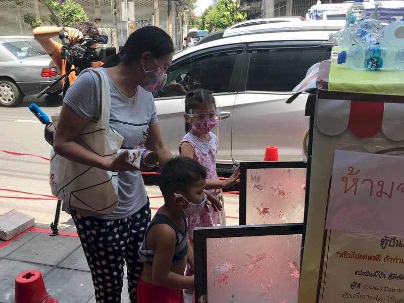 武漢肺炎疫情影響許多人生計，善心人士在曼谷路邊設置食物分享櫃，讓有需要的弱勢民眾自行拿取食物，常有民眾帶著孩子來取食物。