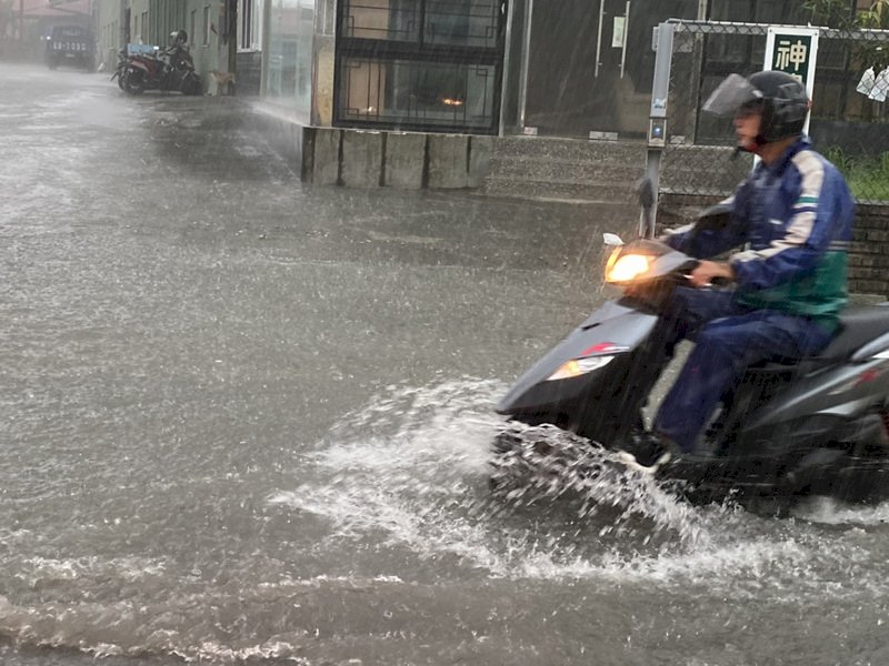 高雄市區22日有間歇性大雨，上班尖峰時間降雨不斷，鳥松區神農路一帶積水約半個輪胎深，騎士一早水中行備感不便。（民眾提供）