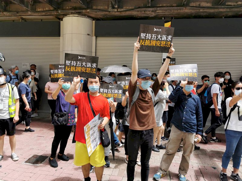 港區國安法6月30日深夜生效後，有香港民眾7月1日在銅鑼灣崇光百貨外高舉抗議標語，表示堅持「反送中」五大訴求，反抗國安惡法。