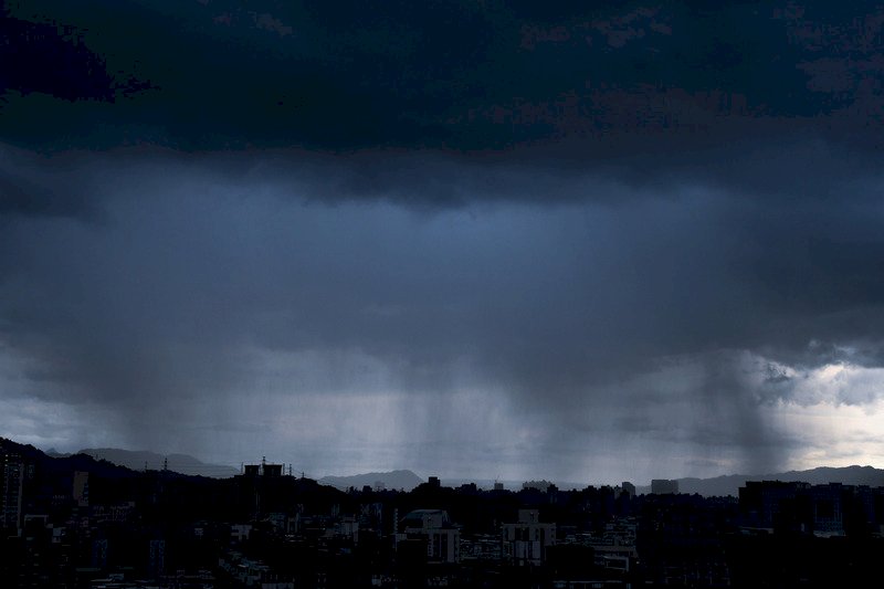 受到對流雲系發展旺盛影響，中央氣象局1日下午3時25分持續針對14縣市發出豪雨及大雨特報。圖為從新北市中和區高處遠眺土城方向，出現雨瀑現象。
