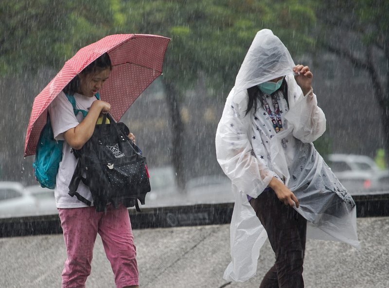 全台晴朗炎熱，午後對流雲系發展旺盛，中央氣象局19日發布14縣市大雨特報，台北市區下起午後雷陣雨，路上行人紛紛快步避雨。