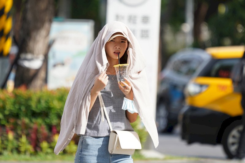 天氣晴朗炎熱，高溫屢創紀錄，中央氣象局24日觀測到台北出現攝氏39.7度高溫，打破歷史紀錄。街上民眾以衣物遮擋豔陽，喝著清涼飲料消暑。