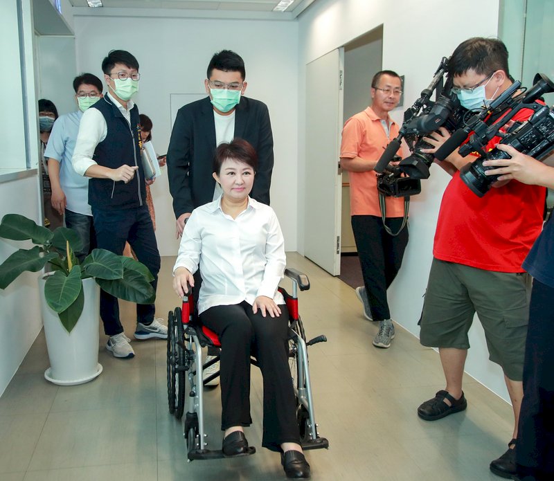 台中市長盧秀燕（前中）請假進行髖關節手術，28日銷假上班，由幕僚推著輪椅進會議室主持市政會議。