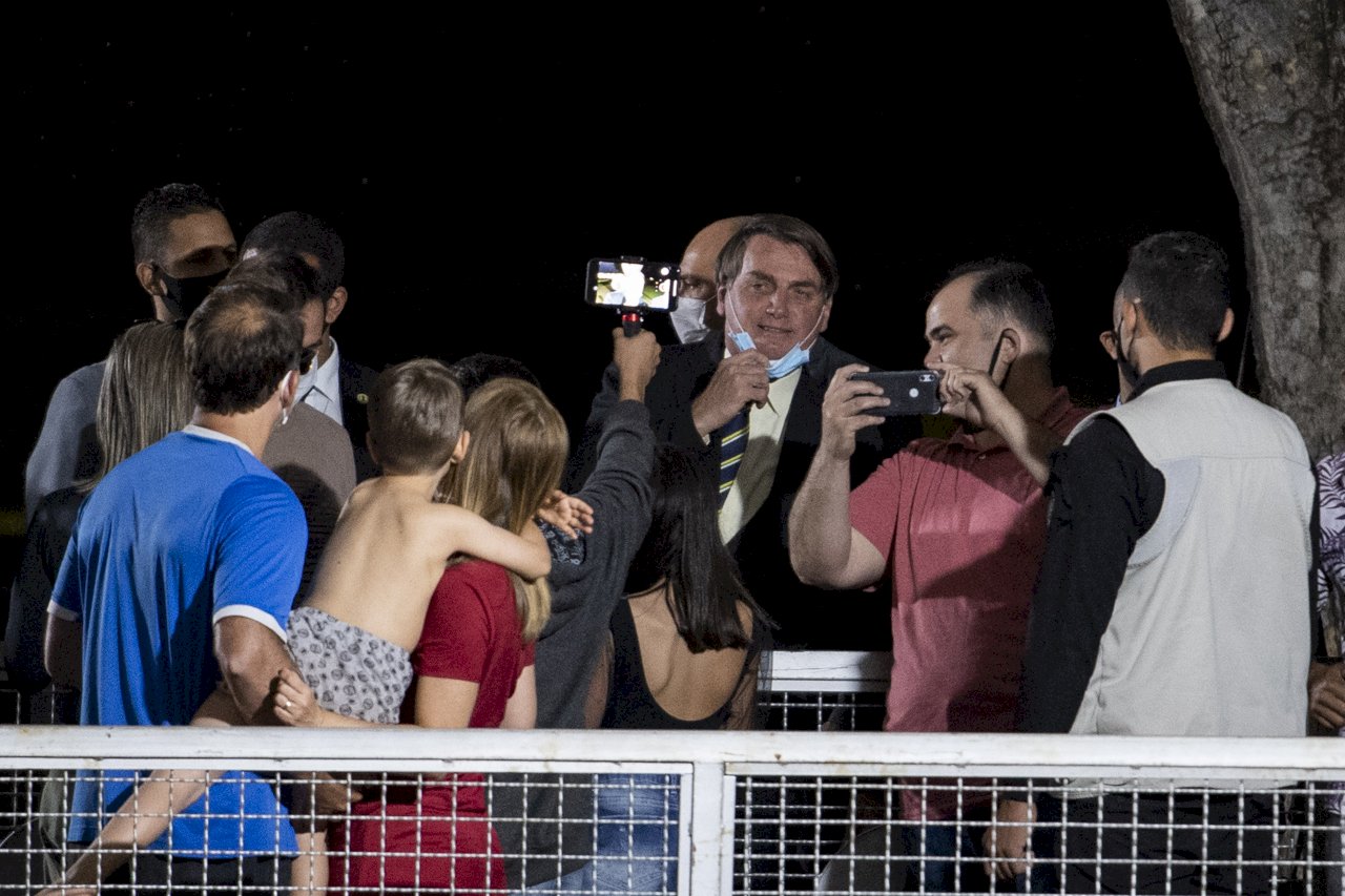 巴西總統波索納洛(Jair Bolsonaro)27日在首都巴西利亞(Brasilia)與支持者致意時，在公共場合把口罩拿下來。(AP/達志影像)