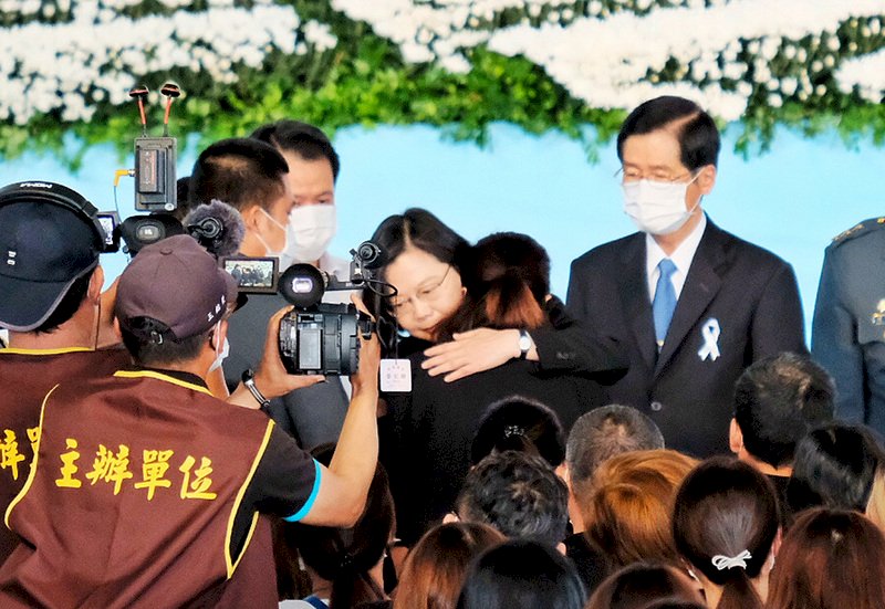 總統蔡英文(中)30日上午在國防部長嚴德發(右)等人陪同下,出席「陸軍航特部英勇殉職飛官聯合公奠」,蔡總統除向殉職飛官簡任專與高嘉隆的忠烈英靈致祭,也逐一慰問遺眷,擁抱致意。