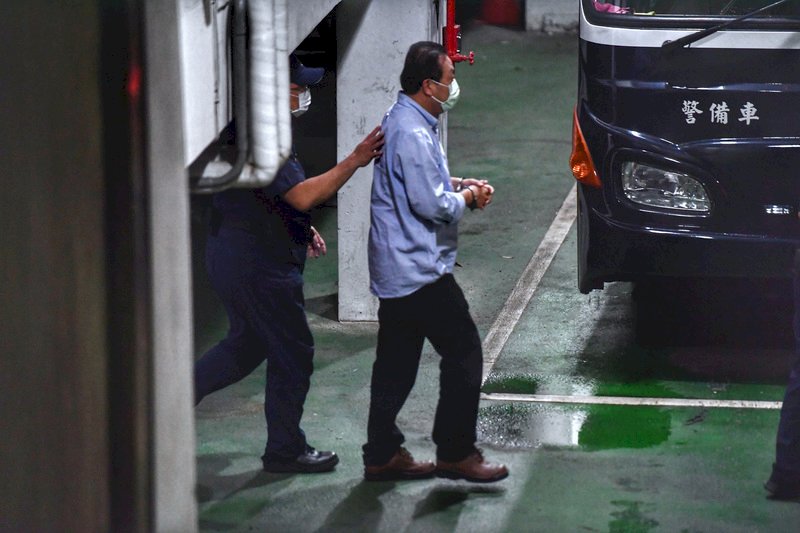 立委涉嫌收賄案，台北地方法院4日裁定民進黨立委蘇震清（右）等人羈押禁見，蘇震清晚間在員警戒護下，戴著手銬準備上囚車。