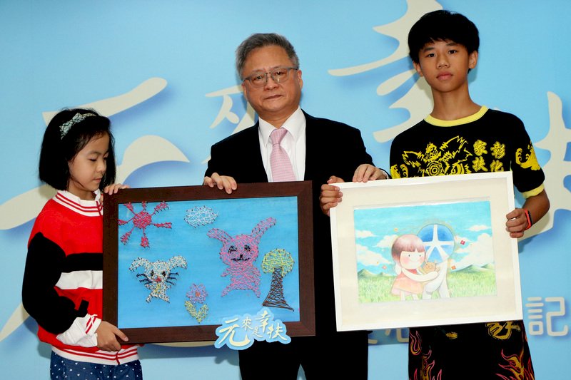 元大金控捐贈「振興經濟愛心卡」給7個社福團體,幫助弱勢家庭。受惠家戶兒童代表6日於記者會中回贈感謝卡片,由元大金控總經理翁健(中)代表接受。