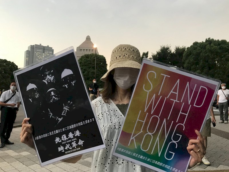 日本跨黨派國會議員12日抗議中共及香港政府蹂躪基本人權，在日港人和挺港日本人也在國會門口發起「守護香港」集會，圖為支持者手持標語出席活動。