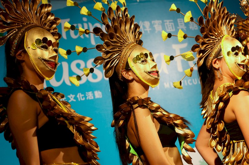 台北市政府20日在台北街頭舉辦菲律賓面具嘉年華活動，參與者戴上面具盛裝打扮，吸引眾人目光。