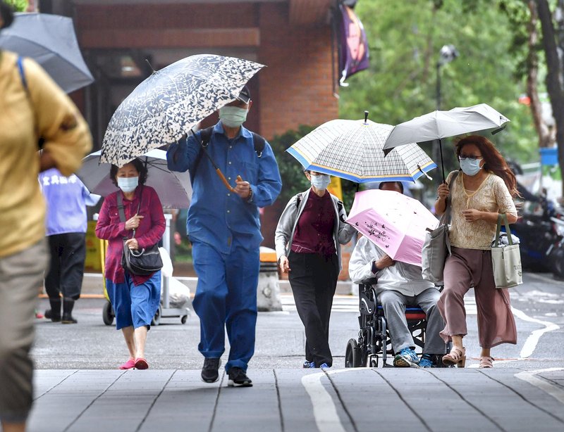 中央氣象局表示，5日北台灣整天轉濕涼，白天高溫僅攝氏24至26度，中南部高溫仍有33、34度，但日夜溫差稍大。圖為台北市街頭民眾撐傘擋細雨。