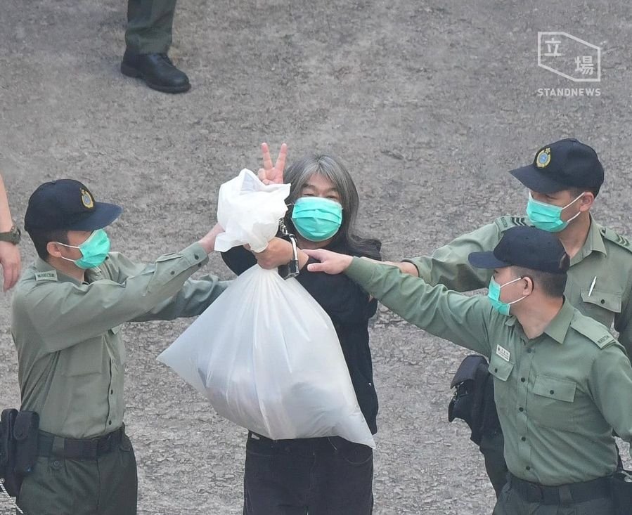 被押上庭應訊 梁國雄高舉V字手勢