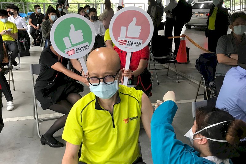 采盟免稅店總經理周招霖(前)5日下午帶領20名桃園機場營業單位一級主管及員工,前往衛福部桃園醫院接種AZ疫苗,盼藉由站在國門第一線的工作伙伴率先施打,既能保護員工也提供顧客最安全的服務。(采盟免稅商店提供) (圖:中央社)
