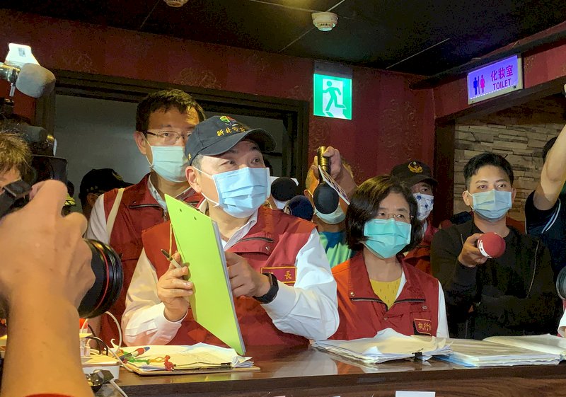 新北市長侯友宜(前左)5日晚間親自帶隊,前往三重區一棟複合式大樓進行公安暨防疫稽查,仔細詢問業者相關措施。侯友宜表示,由於大樓內部複雜且都是密閉型空間,所以要求一定要做到實聯制、量體溫、戴口罩及短時間內密集消毒等,強化防疫。 (圖:中央社)