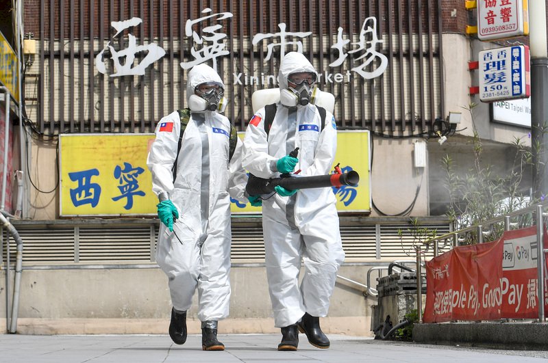 COVID-19台灣本土疫情延燒，國軍化學兵2日上午前往台北市西寧市場，針對市場周遭進行消毒。 (圖：中央社)