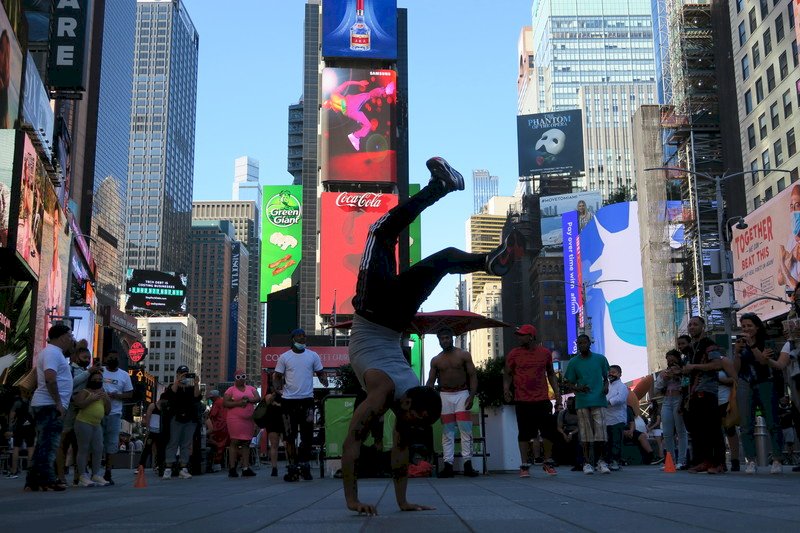 紐約2019冠狀病毒疾病疫情趨緩，熱門景點時報廣場人氣回籠，街頭藝人在民眾圍觀下熱舞。圖攝於6月10日。 (圖：中央社)
