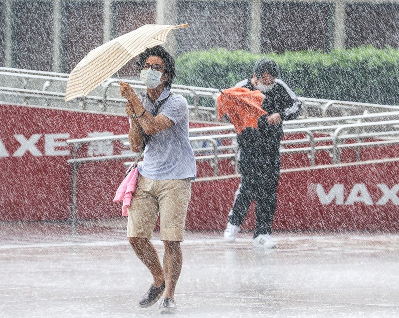 受颱風烟花外圍環流影響,台北市24日上午降下大雨,街頭民眾措手不及,儘管撐傘仍難以抵擋強風和雨勢。 (圖:中央社)
