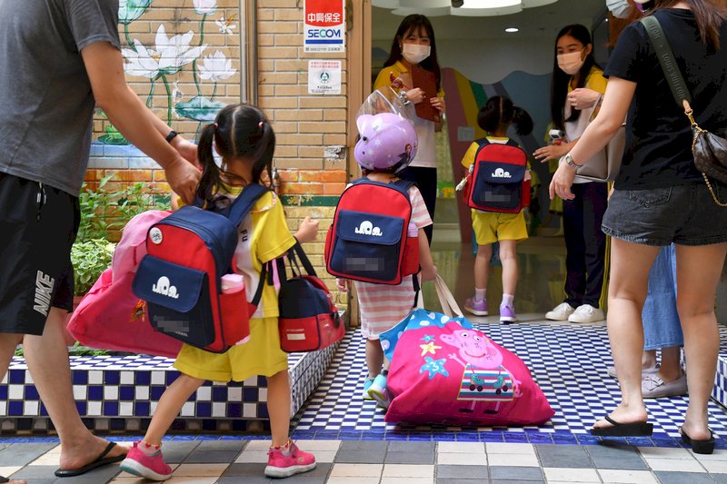 全國COVID-19(2019冠狀病毒疾病)疫情警戒27日降為二級,幼兒園、托嬰中心有條件開放,圖為27日新北市新莊一家幼兒園,家長一早帶著小朋友前來報到。 (圖:中央社)