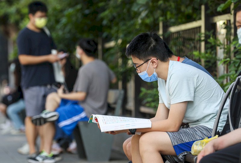 大學指考30日舉行最後一天考試,考科為歷史、地理、公民與社會;有考生在進考場前拿出課本講義複習,做最後衝刺。 (圖:中央社)