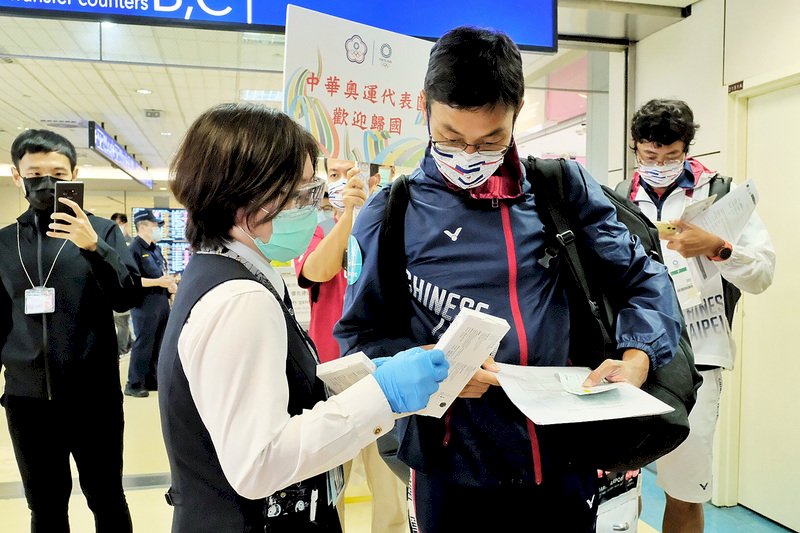網球好手盧彥勳(前右)30日搭機返抵國門,體育署與中華奧會人員前往登機門迎接,並透過奧運代表團歸國檢疫專案,由專人引導通過專屬檢疫、通關作業櫃台,沿途許多海關及檢疫人員,都為他們鼓掌加油,歡迎他回到台灣。 (圖:中央社)