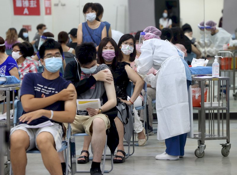 台北長庚醫院28日在台北田徑場為民眾施打BNT及AZ疫苗,民眾坐在椅子上,在醫護人員協助下,依序接種疫苗。中央社記者鄭傑文攝 110年9月28日 (圖:中央社)