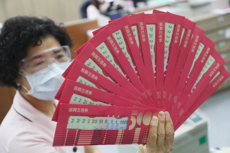 郵局12日開放振興五倍券紙本預約領券,民眾於開放領取期間需攜帶健保卡,依所選時段到預約的郵局領取五倍券。圖為郵局工作人員展示振興五倍券。中央社記者吳家昇攝 110年10月12日 (圖:中央社)