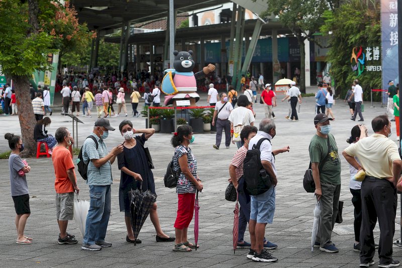 台北市13日開放68歲以上莫德納第2劑在花博接種站施打,現場排隊動線混亂,人龍沿著廣場一路排至捷運站。 (圖:中央社)