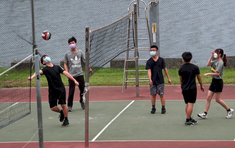 國內COVID-19疫情降溫,繼山林、海濱戴口罩規定鬆綁後,指揮中心16日透露,已研議戶外運動有條件免戴口罩,預計17日宣布相關措施。圖為週末午後,民眾在河濱公園戴著口罩打排球。中央社記者吳家昇攝 110年10月16日 (圖:中央社)