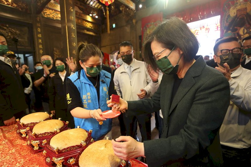 總統蔡英文(前右)26日上午出席「艋舺青山王祭起駕儀式」,將青山宮紅印蓋上大餅。中央社記者吳家昇攝 110年11月26日 (圖:中央社)
