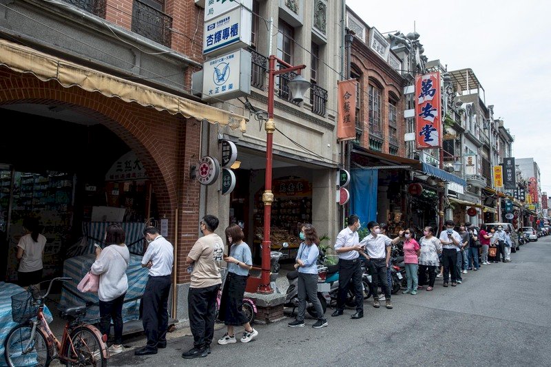 國內COVID-19本土疫情延燒,家用型快篩試劑供不應求,圖為12日上午台北市大稻埕一間藥局門外,民眾排隊等候購買快篩試劑。中央社記者趙世勳攝 111年5月12日 (圖:中央社)